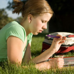 A young girl thinks before writing in the answer for an assignment.