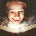 46636842 - woman reading a magic book glowing in the dark