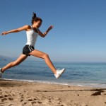 Happy girl running alone on the beach